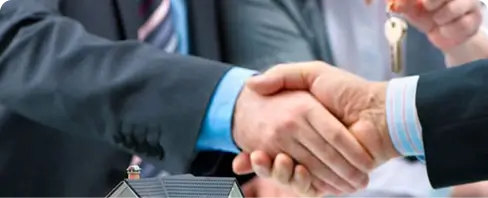 Two business professionals shaking hands representing a residential property management agreement.
